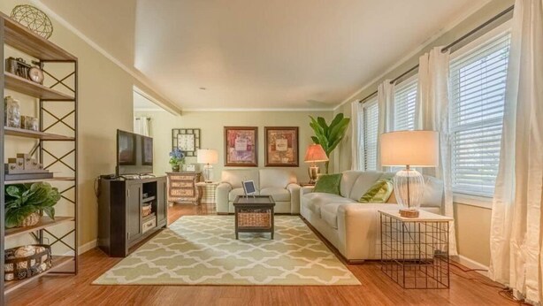 A living room with a sofa, coffee table, TV, and shelves. - Kimball Cottage (Richland)