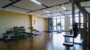 A gym with treadmills, weight machines, and dumbbells. - Tangyi Hotel Zhuhai (Zhuhai)