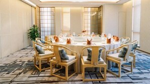 A conference room with a round table, chairs, and a large mirror. - Tangyi Hotel Zhuhai (Zhuhai)