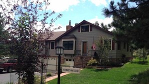 A two-story house with a front yard, a flag, and a street sign. - Serenity Suite-Private Suite close to downtown (Estes Park)