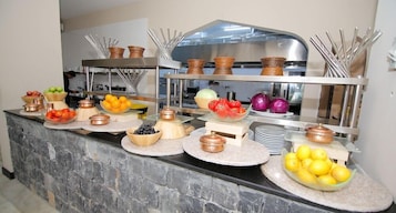 A buffet setup with various food items and serving utensils.