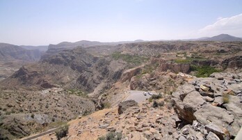 Un paisaje de cañón agreste, con terreno rocoso y vegetación escasa.