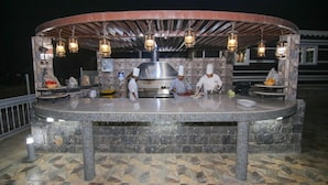 An outdoor kitchen with a stone-tiled floor, a metal counter, and hanging lanterns. - Sama Hotel Al Jabal Akhdhar (Sayq)