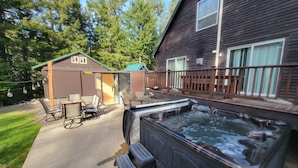 A hot tub, outdoor seating, and a wooden deck. - Cozy Cabin with hot tub, Sauna & outdoor kitchen! (Ronald)