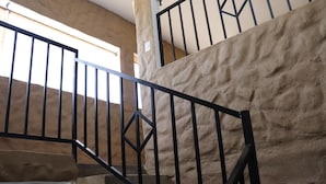 A staircase with black metal railings and beige walls.