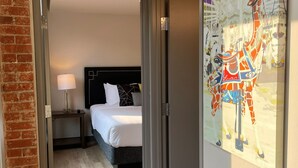 Ein Hotelzimmer mit einem Bett, einem Nachttisch, einer Lampe und einer Giraffen-Zeichnung an der Wand.