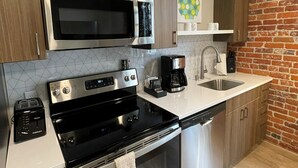 A modern kitchen with stainless steel appliances, a coffee maker, and a dishwasher.