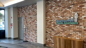 A reception area with a brick wall, a wooden reception desk, and a curved bench.