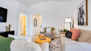 A modern living room with a sofa, armchair, coffee table, and a TV mounted on the wall. - Beautiful 2/2 in Springfield 55+ Golf Community 30 night minimum (Chandler)