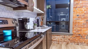 A modern kitchen with a built-in oven, coffee maker, and dishwasher.
