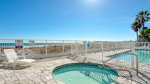 A pool area with a view of the ocean, a fenced deck, and a lounge chair. - Fourwinds 803-Cozy Beachfront condo-Hall Bunks-less crowded beaches-Epic Views (Orange Beach)