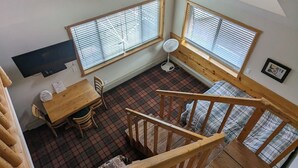 A high-ceilinged room with a wooden staircase, a dining area with a table and chairs, and two windows with blinds. - LAKEFRONT FISHING LODGE RETREAT SLEEPS 50! BOAT RENTALS! WORLD CLASS FISHING! (Panguitch)