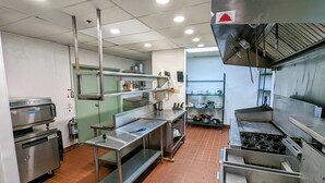 A commercial kitchen with stainless steel appliances, a fire extinguisher, and a tiled floor. - LAKEFRONT FISHING LODGE RETREAT SLEEPS 50! BOAT RENTALS! WORLD CLASS FISHING! (Panguitch)