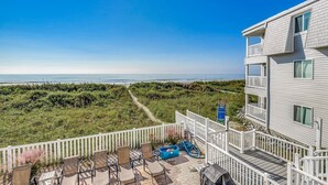 Una propiedad frente a la playa con patio, mobiliario exterior y vista al océano.
