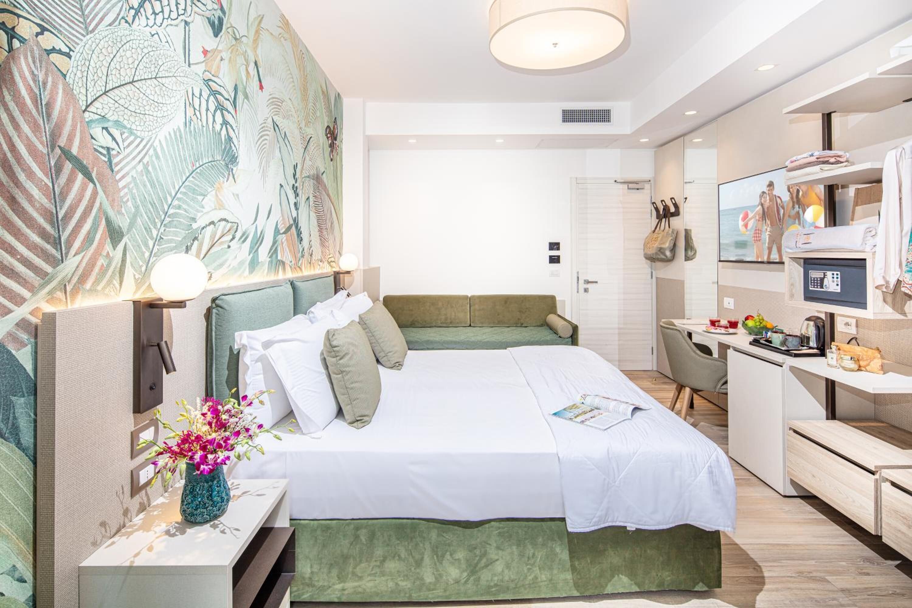 Una habitación de hotel moderna con una cama grande, un escritorio y una televisión.