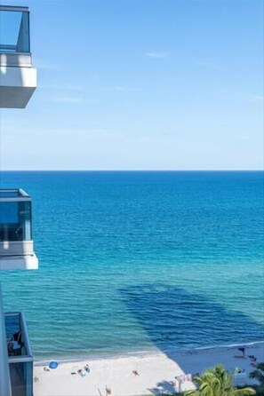 Enjoy breathtaking ocean views from the spacious balcony with a clear view of the sandy shore and palm trees.