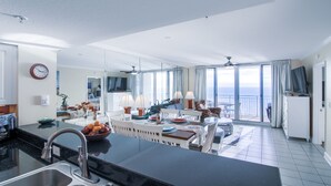 Eine moderne Küche mit Kochinsel, ein Essbereich mit Aussicht und ein Balkon mit Blick.