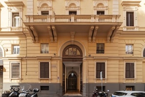 A building with a symmetrical facade, large windows, and a central entrance with an archway.