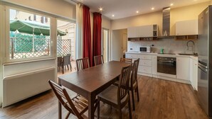 A modern kitchen with white cabinets, a wooden dining table, and chairs.