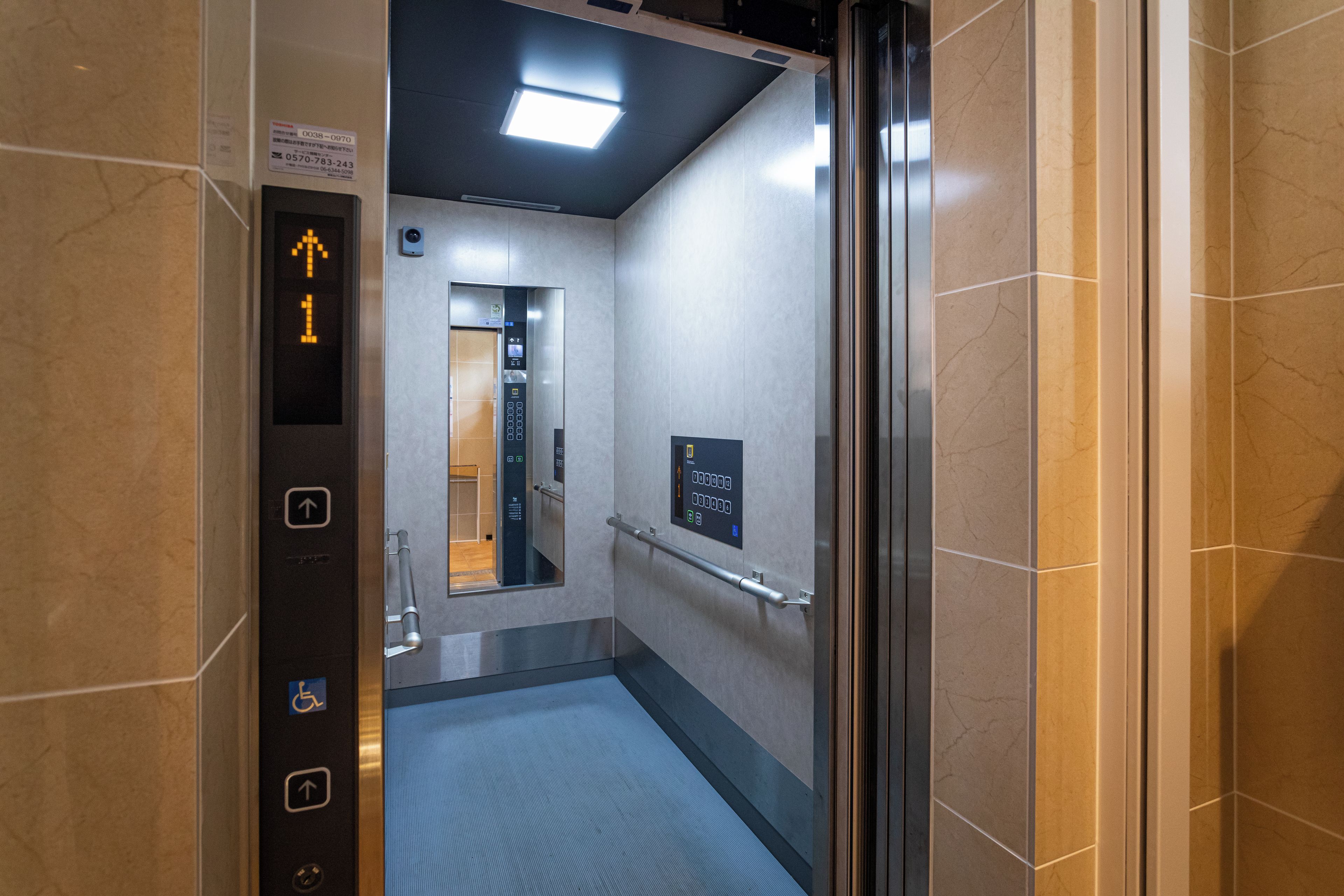 An elevator interior with a handrail, a digital display, and a floor indicator.