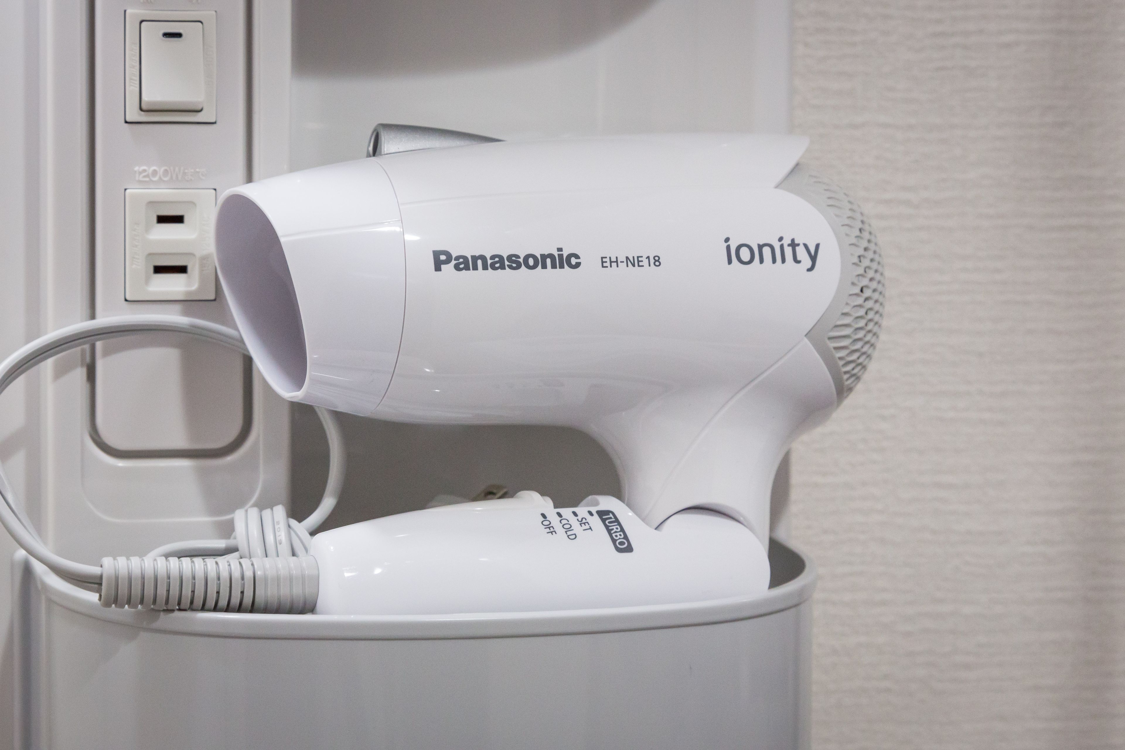 A Panasonic ionity hair dryer in a white charging station.
