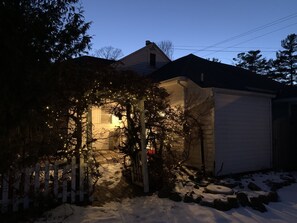 A house with a snow-covered porch and a small window. - Charming garden cottage downtown Ellison Bay walking distance to lake and shops (Ellison Bay)