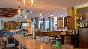 Un espace bar doté d’un long comptoir, de nombreux tabourets et d’une variété de bouteilles et de verres.