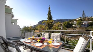 Une table à manger avec des chaises et une vue sur une colline.