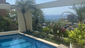 Une piscine offrant une vue sur la ville et la mer.
