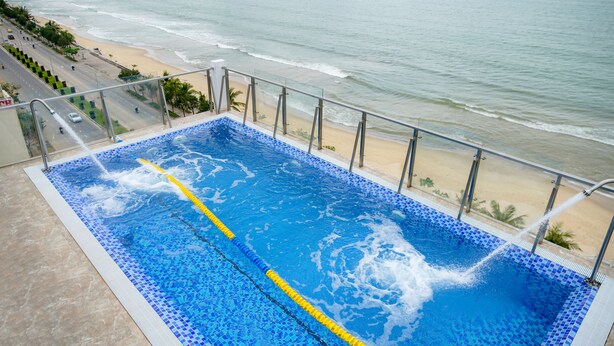 Una piscina con vista a la playa y al océano.