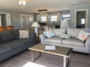 Relax in this inviting living room with a sofa, coffee table, and kitchen area.