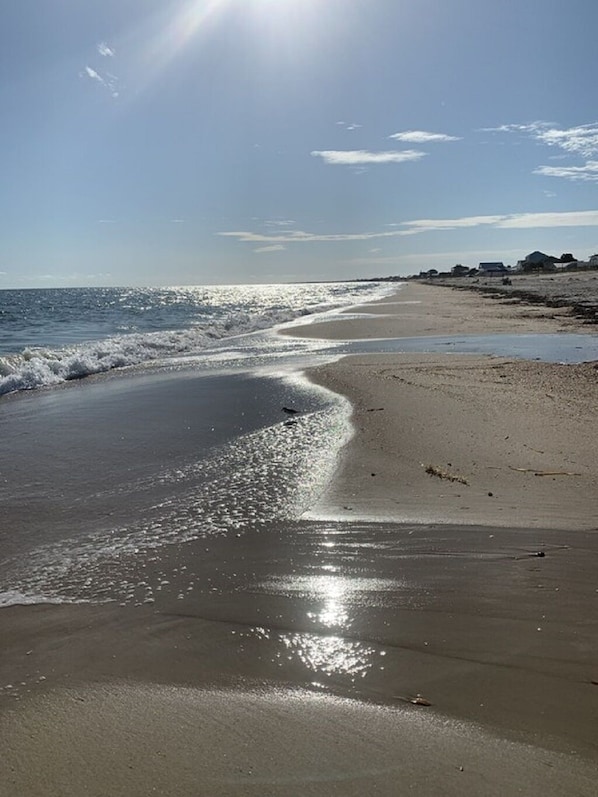 Enjoy a serene beach experience with gentle waves and a calm sea.