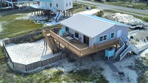 A beachfront house with a deck, outdoor seating, and a covered porch. - Affordable 2 bed, 1.5 bath Beach views. Hot tub, Pet friendly, fenced back yard. (Saint George Island)