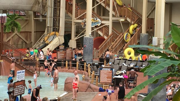 Un parc aquàtic interior amb diverses tobogans, una zona de jocs aquàtics i una zona de piscines.