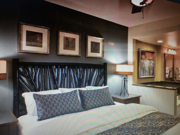 A hotel room with a bed, a bedside table, a lamp, and framed pictures on the wall. - Wyndham Resorts 1BR @ Wilderness Lodge (Sevierville)