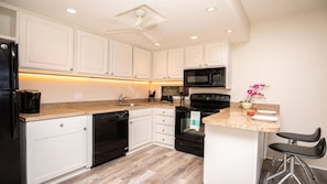 Enjoy cooking in this well-equipped kitchen with a sink, refrigerator, coffee maker, and more.