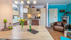Una cocina moderna con armarios de madera, una mesa de comedor con tulipanes y un sillón de cuero.