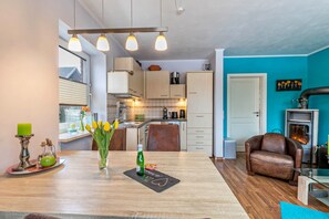 Une cuisine moderne avec des meubles en bois, une table à manger décorée de tulipes et un fauteuil en cuir.