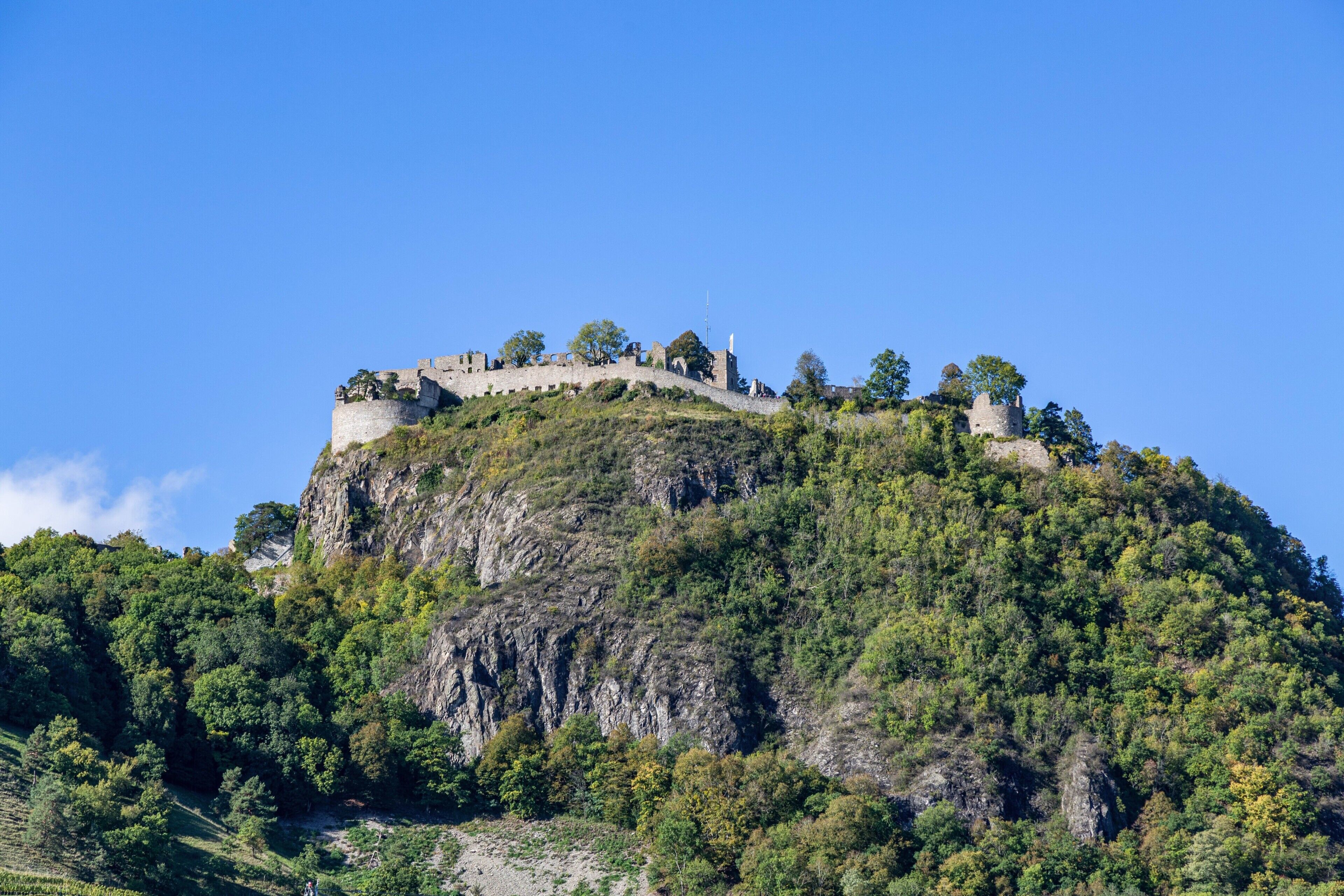 Eine Burg auf einem Hügel, bewölkter Himmel.