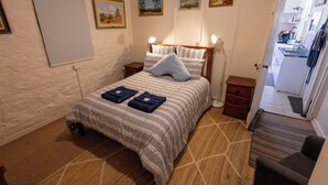 A bedroom with a bed, bedside tables, a whiteboard, and framed pictures on the wall. - Hawker Bed and Breakfast (Hawker)