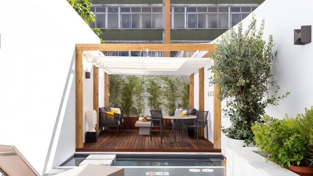 A rooftop patio with a wooden deck, a covered seating area, and a pool. - STUPENDO-2BR- Patio, Refresh Pond-A/C-Center (Lisboa)
