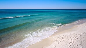 A beach with clear turquoise water and a sandy shore.