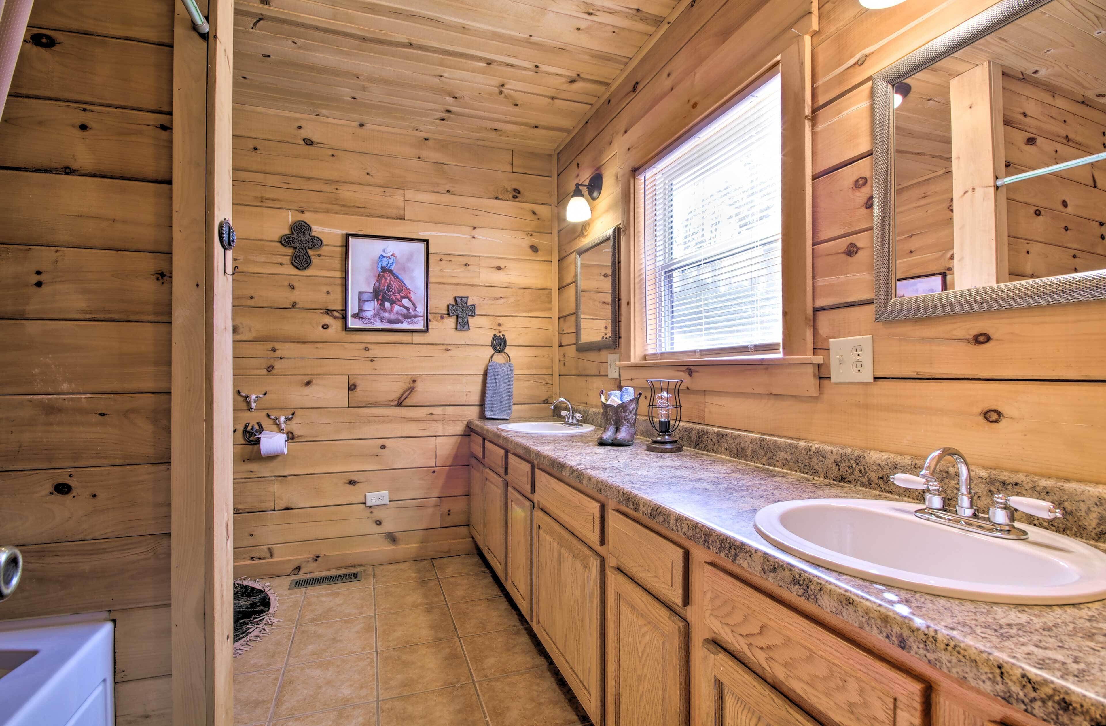 Une salle de bain rustique, avec des murs en bois, comprenant un lavabo, un meuble-lavabo et un grand miroir.