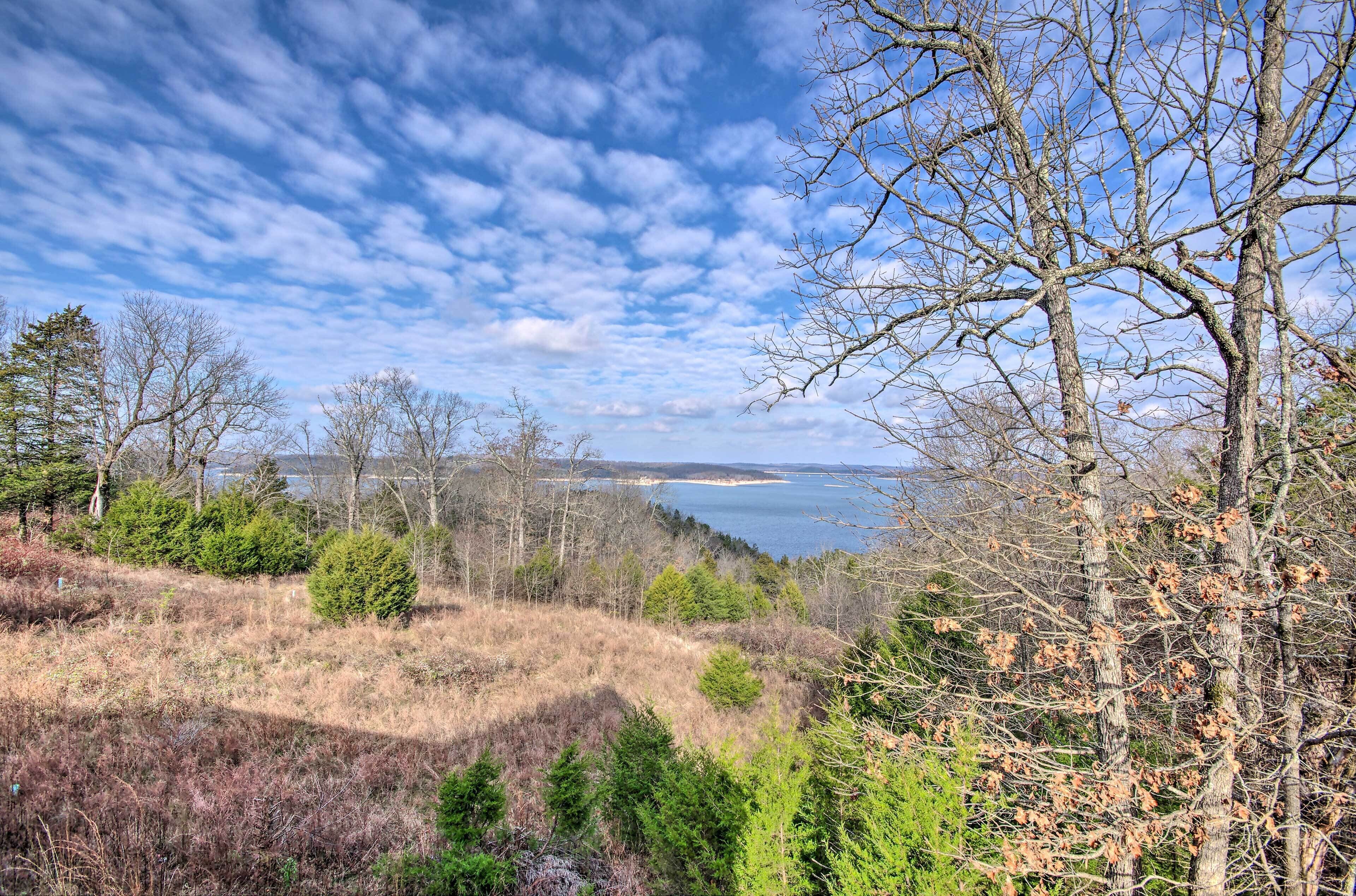 A coastal landscape with trees, shrubs, and a view of the sea.