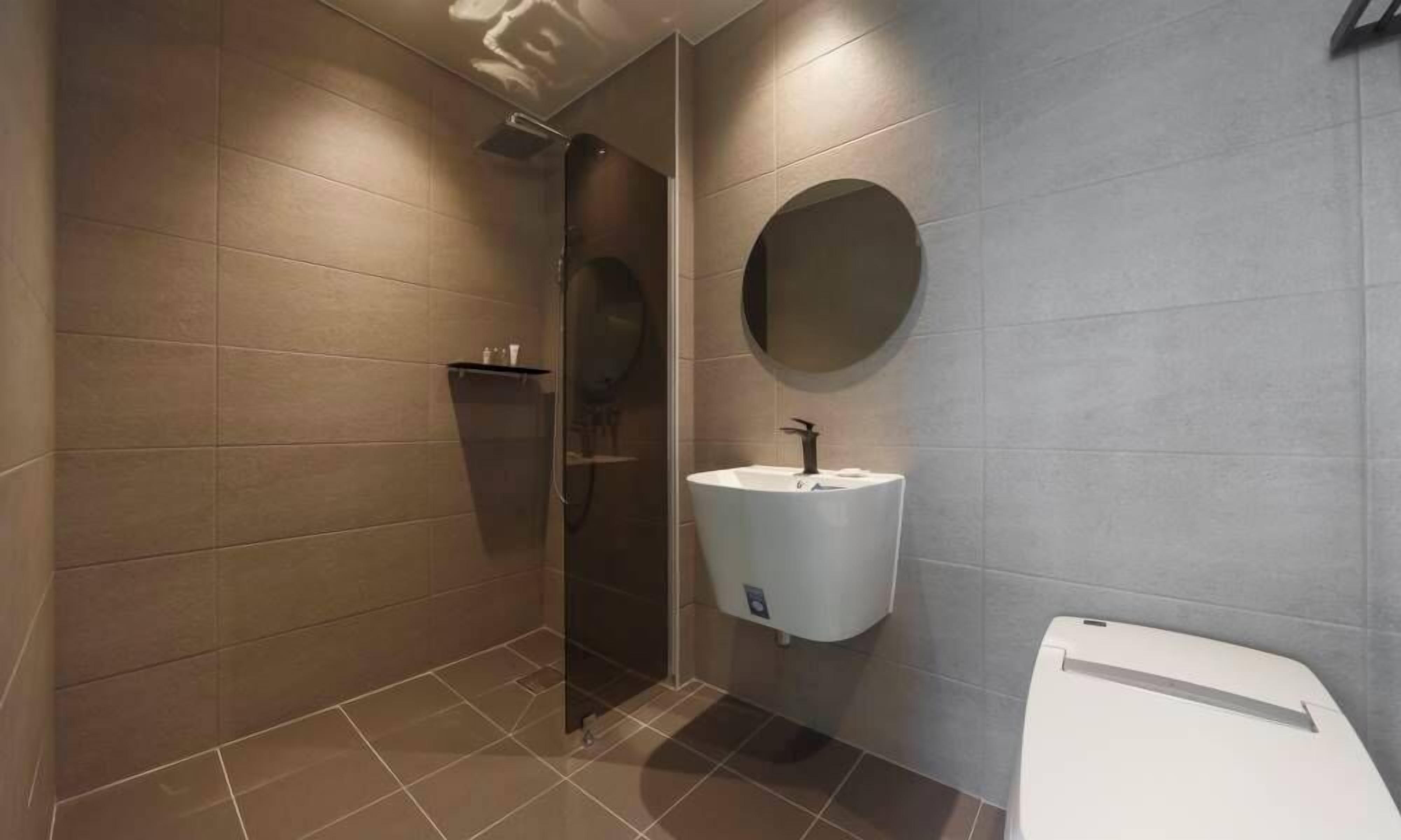Un baño moderno con ducha, lavabo e inodoro.