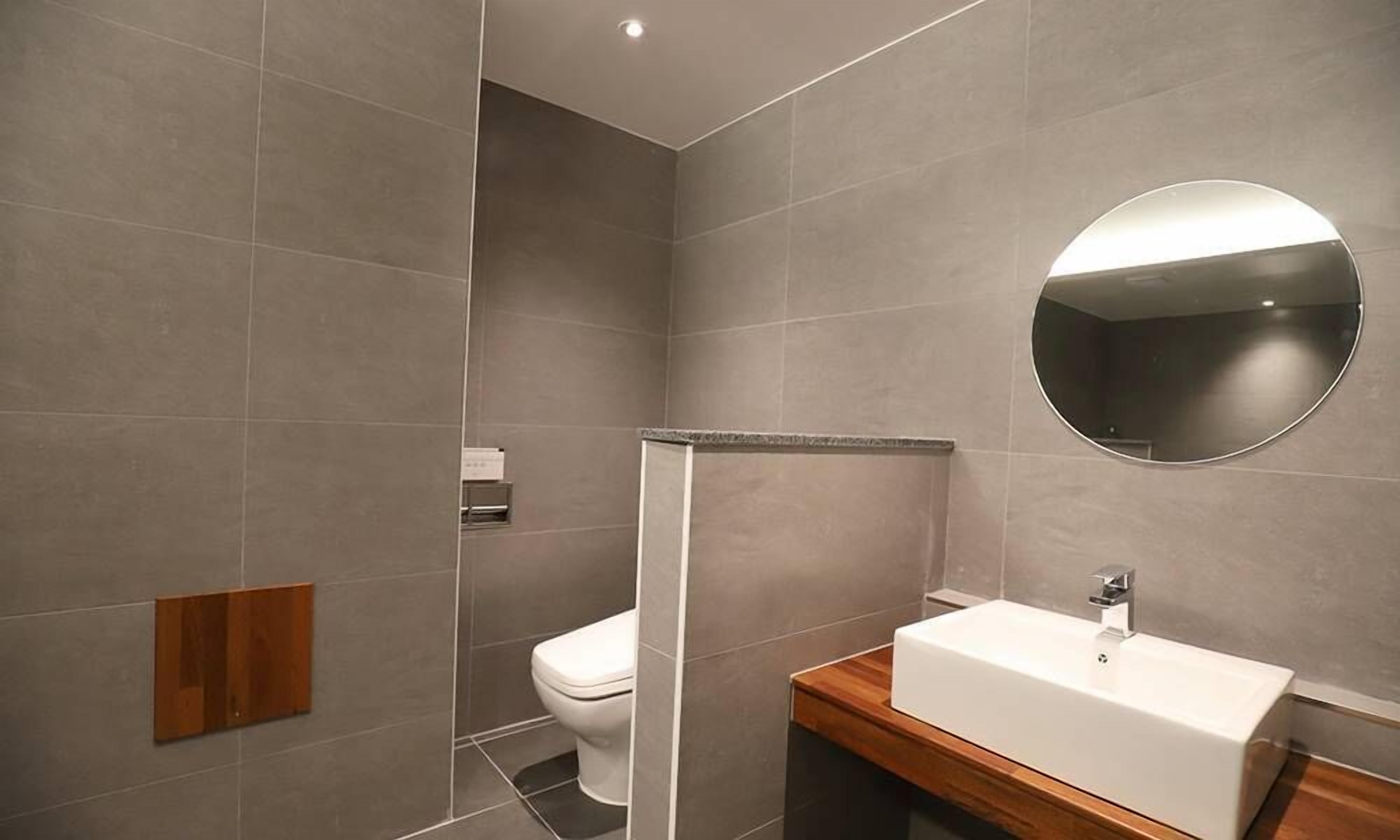 Un baño moderno con inodoro, ducha y lavamanos.