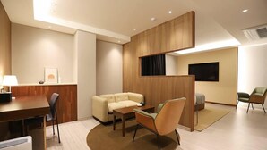 A modern hotel room with a wooden partition, a sofa, a dining table, and a TV. - Dongdaegu Station Eastern Hotel (Daegu)