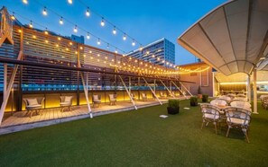 An outdoor seating area with string lights, a covered section, and a grassy lawn. - Dongdaegu Station Eastern Hotel (Daegu)