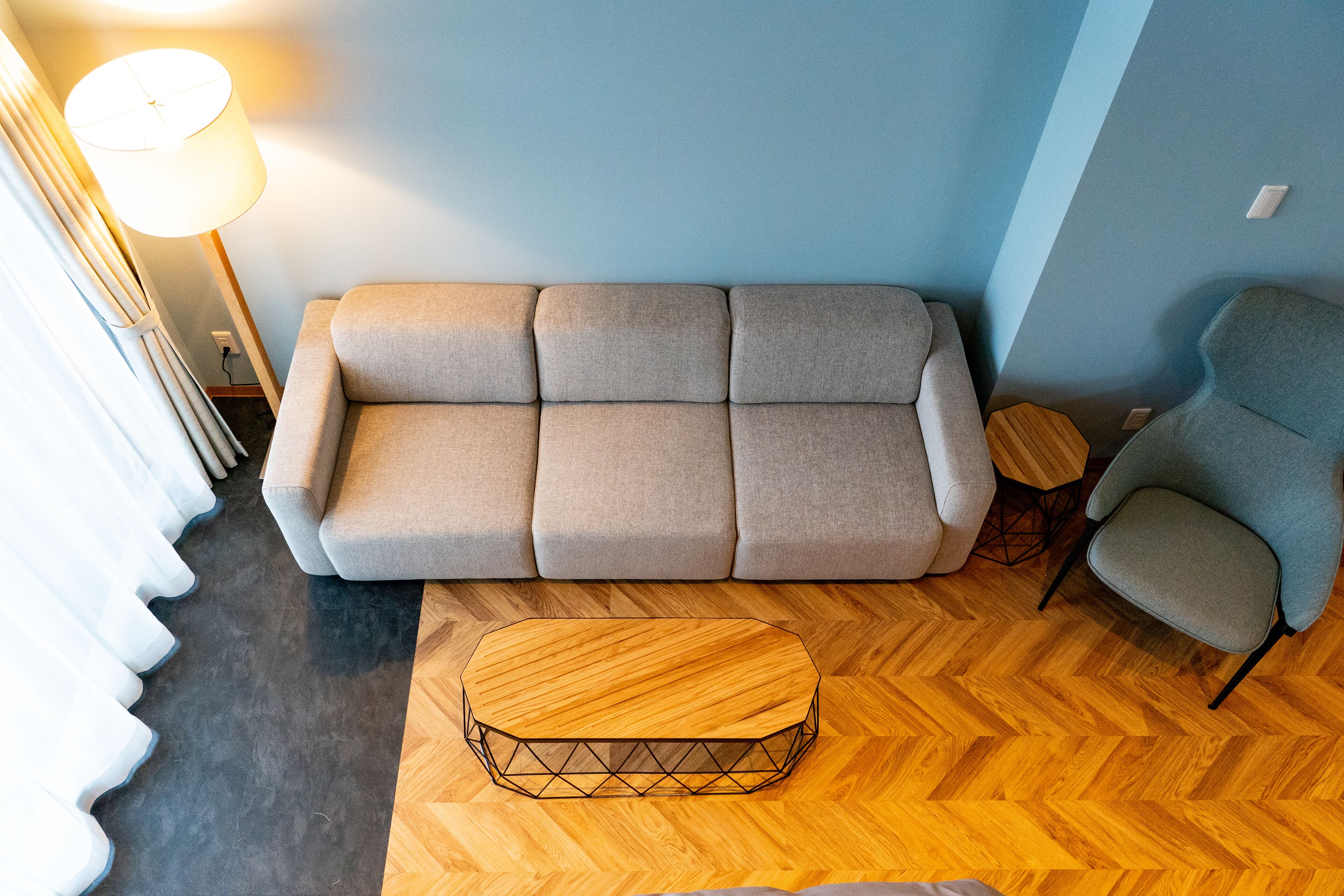 Una sala moderna con un sofá, una mesa de centro de madera y una silla.
