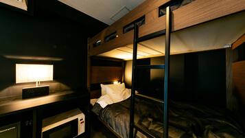 Dormitorio con literas, escritorio y microondas.